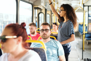 Multicultural group of people riding in the city bus.