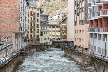 Obraz na płótnie Canvas ESCALDES-ENGORDANY, ANDORRA - February 1: River Valira on Engordany Bridge and houses view in a snowfall day in small town Escaldes-Engordany in Andorra on January 16, 2013.