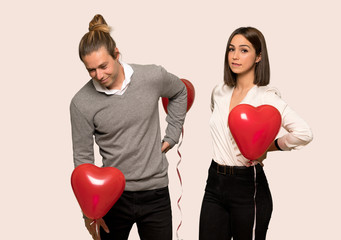 Couple in valentine day suffering from backache for having made an effort over isolated background