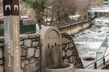Fototapeta premium ESCALDES-ENGORDANY, ANDORRA - February 1: River Valira on Engordany Bridge and houses view in a snowfall day in small town Escaldes-Engordany in Andorra on January 16, 2013.