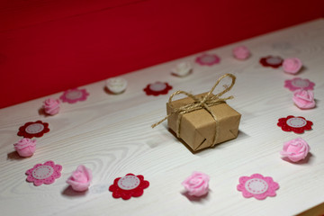 gift and flower heart on white table