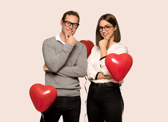 Fototapeta na wymiar Couple in valentine day with glasses and smiling over isolated background