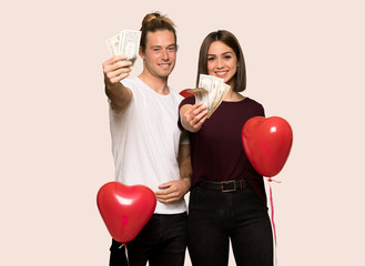 Couple in valentine day taking a lot of money over isolated background