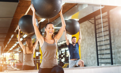 Smiling happy Caucasian Couple in sportswear doing pilates exercises in gym.