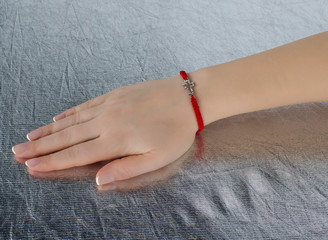 red thread with a cross on the hand of a girl