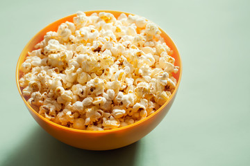 An orange bowl with popcorn isolated