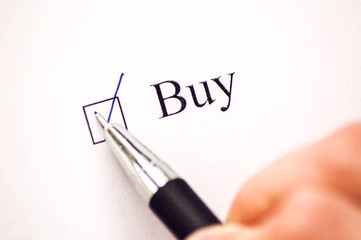 Buy - checkbox with a cross on white paper with pen. Checklist concept.