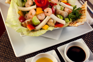 Sea food salad with sauces on white plate. Food and restaurant concept