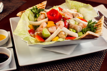Sea food salad with sauces on white plate. Food and restaurant concept