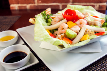 Sea food salad with sauces on white plate. Food and restaurant concept