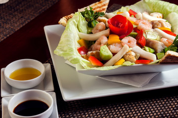 Sea food salad with sauces on white plate. Food and restaurant concept