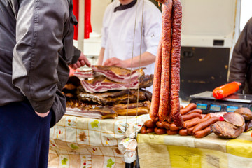 Selling smoked meat on stall, street market.