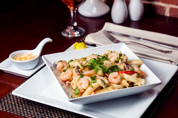 Penne (pasta) with shrimps/prawns and sausage in pomodoro (tomato) sauce - Italian cuisine, cooking, culinary (traditional authentic taste). Food and restaurant concept