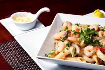 Penne (pasta) with shrimps/prawns and sausage in pomodoro (tomato) sauce - Italian cuisine, cooking, culinary (traditional authentic taste). Food and restaurant concept