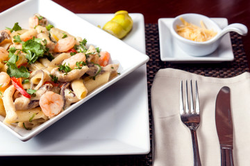 Penne (pasta) with shrimps/prawns and sausage in pomodoro (tomato) sauce - Italian cuisine, cooking, culinary (traditional authentic taste). Food and restaurant concept