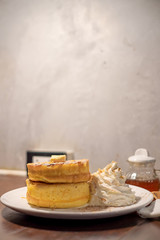 Fluffy Japan souffle pancakes, hotcakes with honey syrup and butter light concrete background copy space