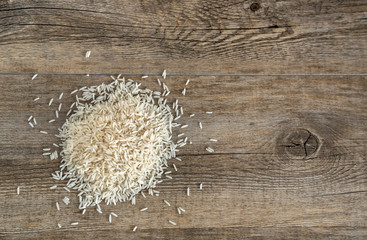 Top view of Basmati Rice pile on the antique wooden background. 