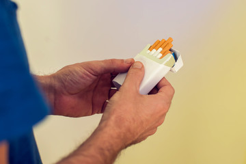 Closeup Of Male Hand Holding Cigarettes Pack. People And Smoking Concept.