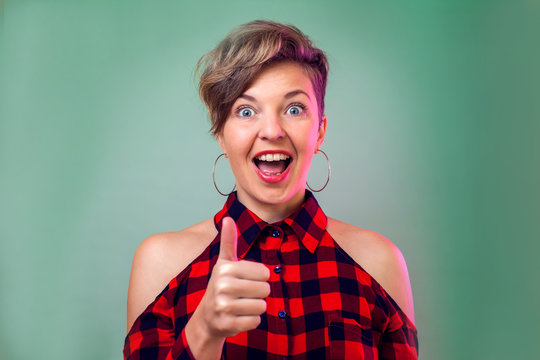 People and emotions - a portrait of smiling woman with short dark hair showing thumbs up