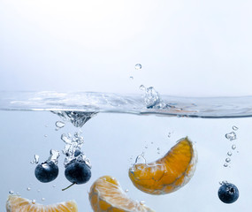 Orange Segments and Blueberries under Water