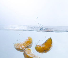 Orange Segments Splashing Into Water