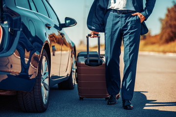 Senior businessman traveling to work wit car.