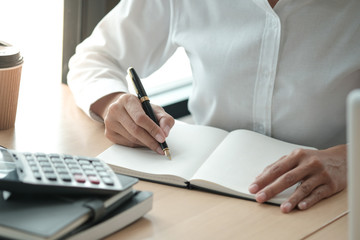 Businesswoman analyzing investment charts and pressing calculator buttons over documents. Accounting Concept.