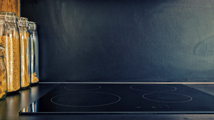 Modern black kitchen with induction cooktop - obrazy, fototapety, plakaty
