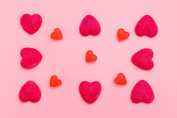 Valentine's day background Top view Pattern with different heart-shaped pink and red candies on a light pink backdrop