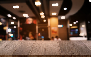 Empty dark wooden table in front of abstract blurred bokeh background of restaurant . can be used for display or montage your products.Mock up for space.