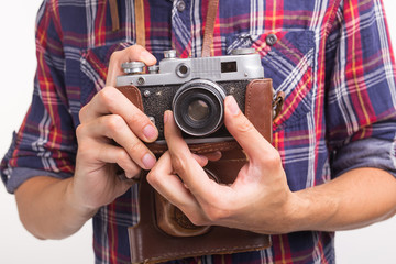 Vintage, photographer and hobby concept - close up of retro camera in man's hands over the white background