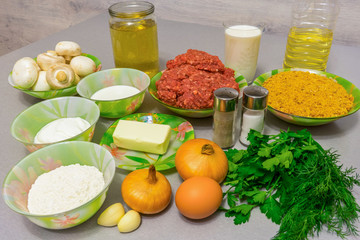 Ingredients for cooking meatballs with stroganoff gravy: minced meat, mushrooms, breadcrumbs, milk, egg, onion, garlic, oil, butter, sour cream, heavy cream, broth, flour, fresh herbs, salt, pepper