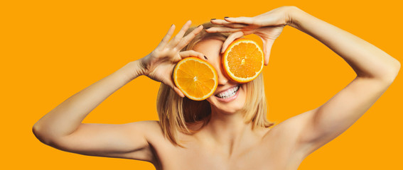 beautiful stylish girl holding orange smiling and looking at camera isolated