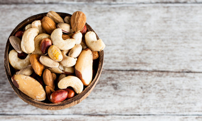 Healthy mix nuts on wooden background. Almonds, hazelnuts, cashews, peanuts, pistachios, brazilian nuts