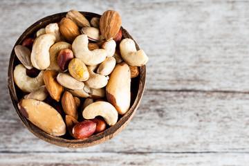 Healthy mix nuts on wooden background. Almonds, hazelnuts, cashews, peanuts, pistachios, brazilian nuts