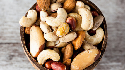 Healthy mix nuts on wooden background. Almonds, hazelnuts, cashews, peanuts, pistachios, brazilian nuts