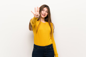 Young woman with yellow sweater happy and counting four with fingers