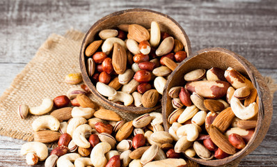 Healthy mix nuts on wooden background. Almonds, hazelnuts, cashews, peanuts, pistachios, brazilian nuts