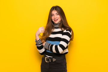 Young woman over yellow wall With happy expression
