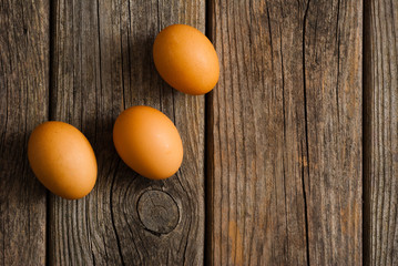 three eggs on weathered wooden table