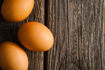 three eggs on weathered wooden table