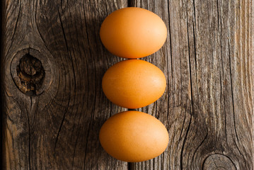 three eggs on weathered wooden table