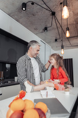 Small girl in a red dress laughing together with her father