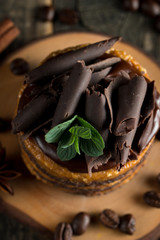 Chocolate cakes on black slatter board with mint, coffee beans on dark background, closeup photo. Fresh, tasty dessert food concept. 