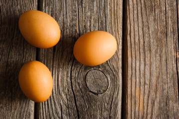 three eggs on weathered wooden table