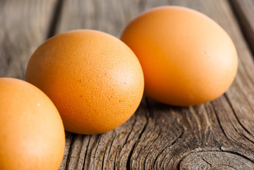 three eggs on weathered wooden table