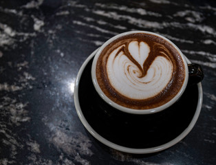 Cup of coffee with heart symbol on top