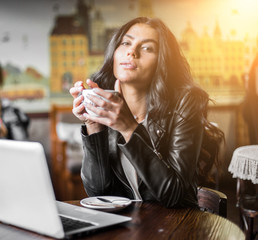 Young pretty spanish woman in cafe in city centre with tablet laptop