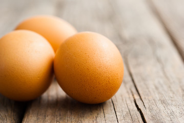 three eggs on weathered wooden table