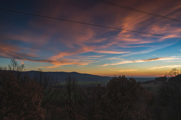 A scenic sunset over a wooded area.